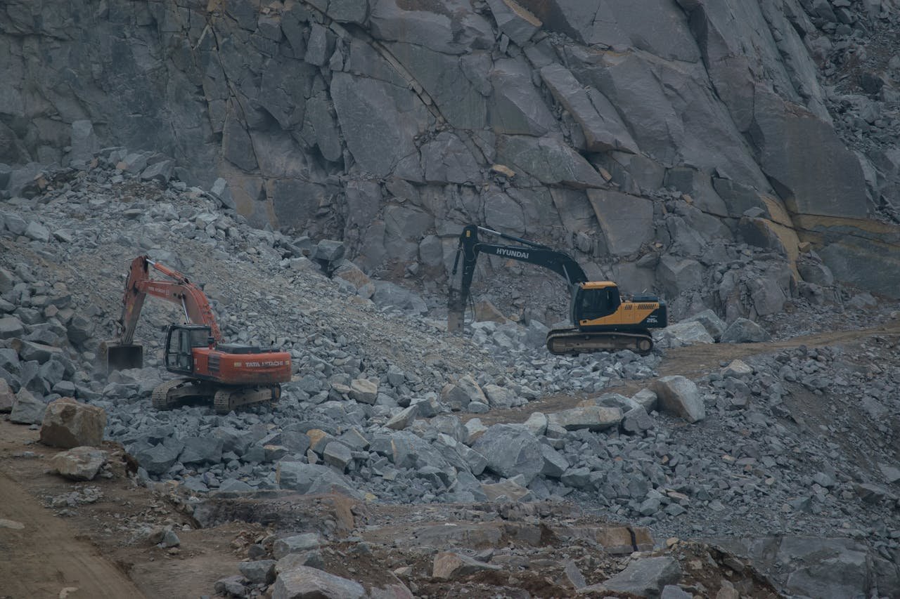 about-img Dynamic construction site featuring excavators working on rocky terrain.